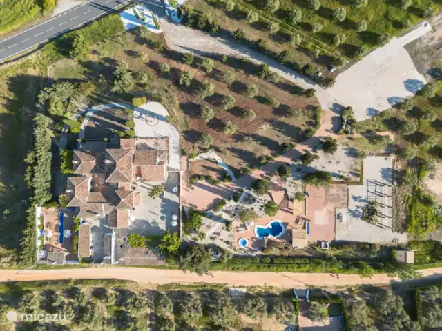 Van boven overzicht van de finca, zwembad en terrassen.